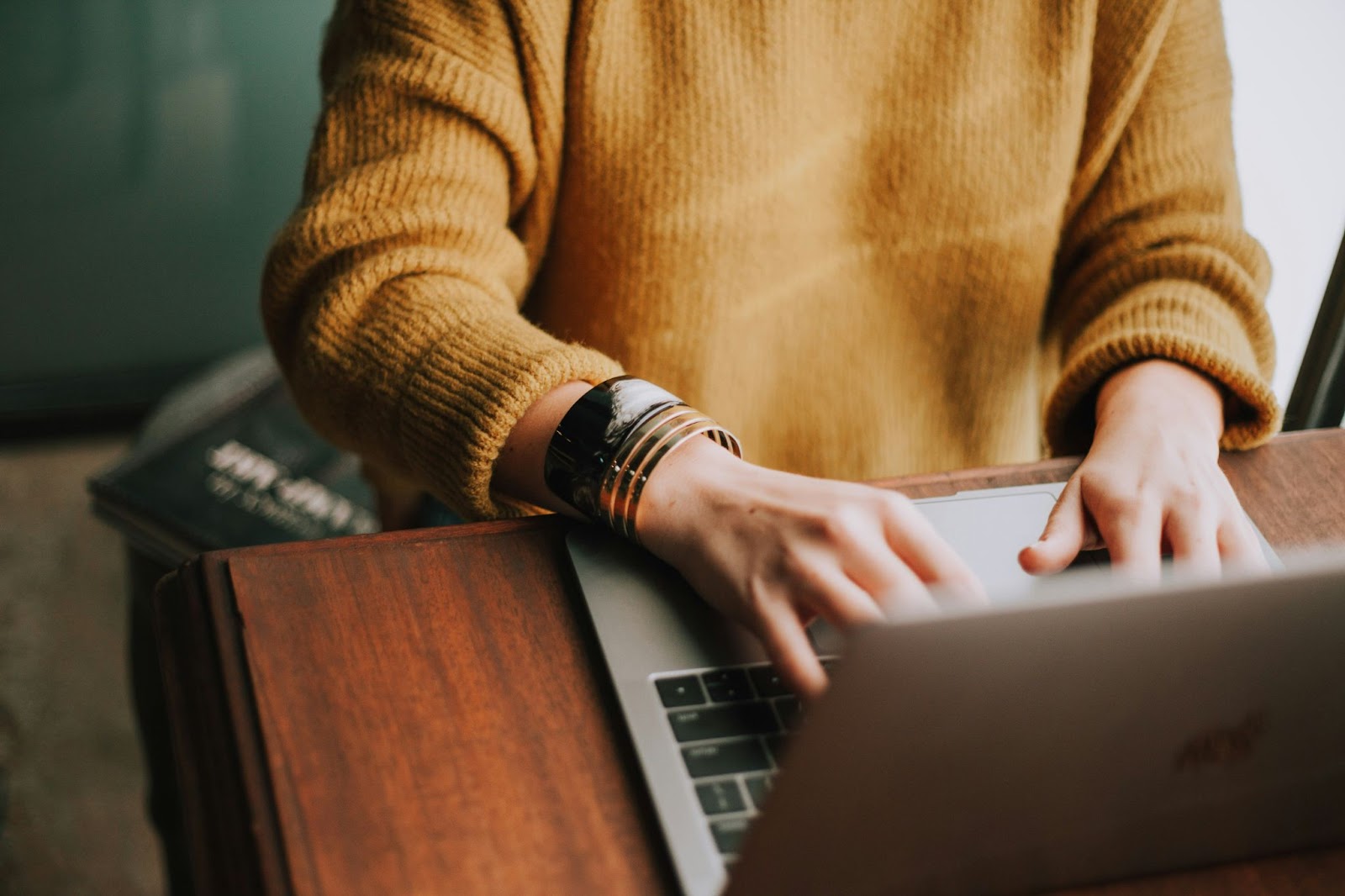 Person seated at desk with hands typing on keyboard